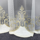 Decorative sheer curtain with gold embroidery on a dark background