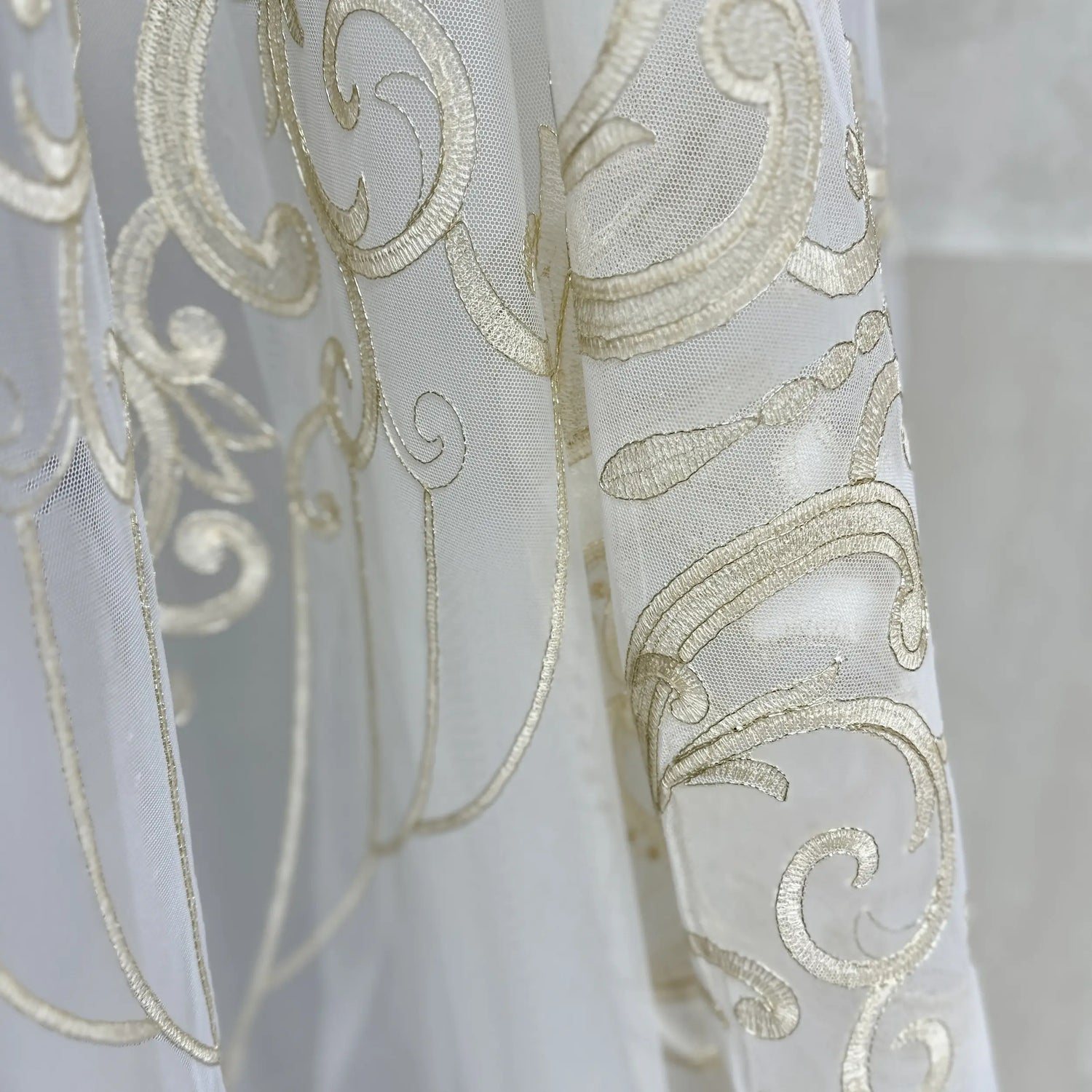 Close-up of a white fabric with gold embroidery on a blurred background