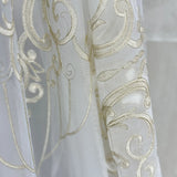 Close-up of a white fabric with gold embroidery on a blurred background