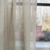Textured beige curtain with outdoor scene in the background