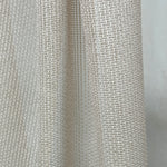 Close-up of textured beige curtains fabric with a subtle pattern