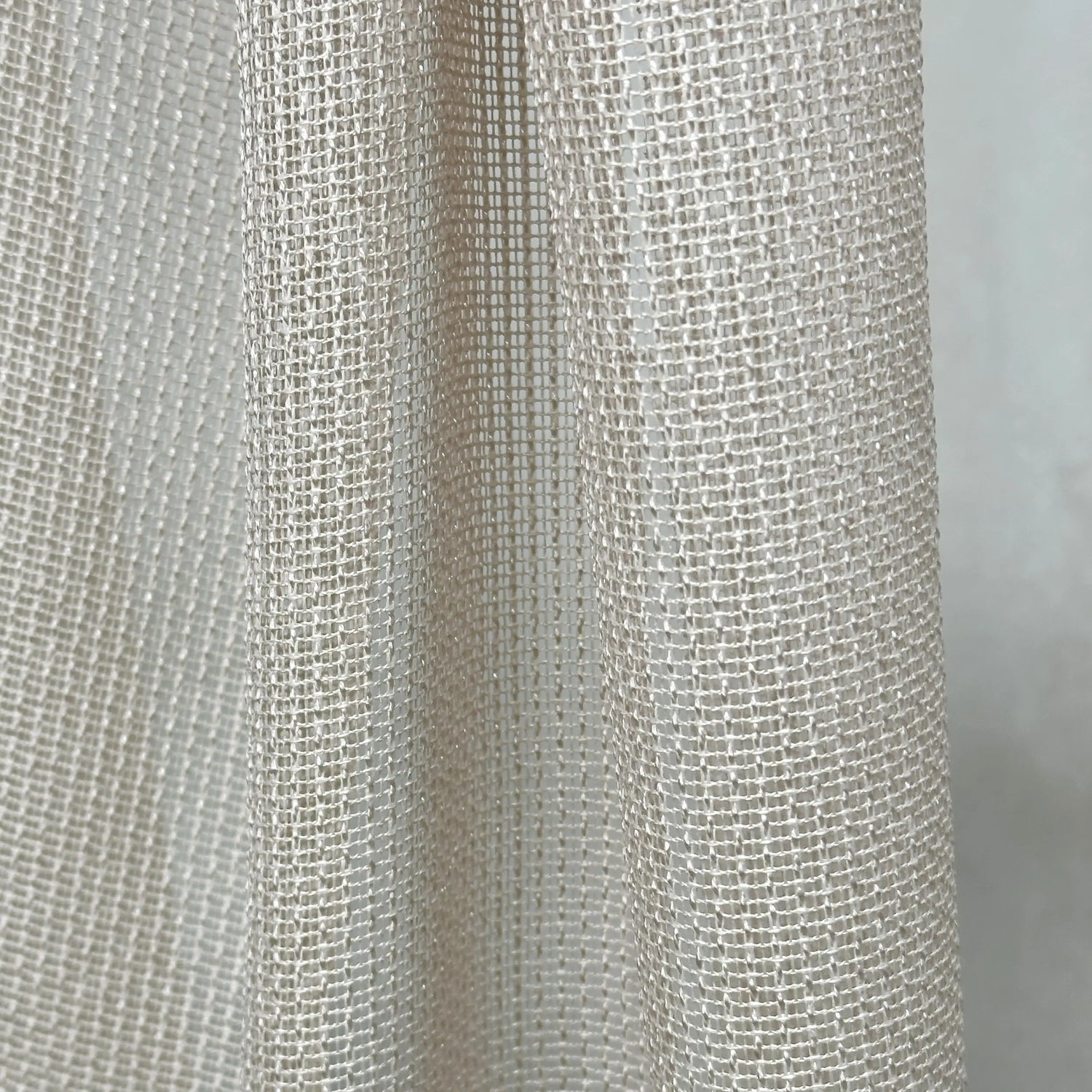 Close-up of textured beige curtains fabric with a subtle pattern