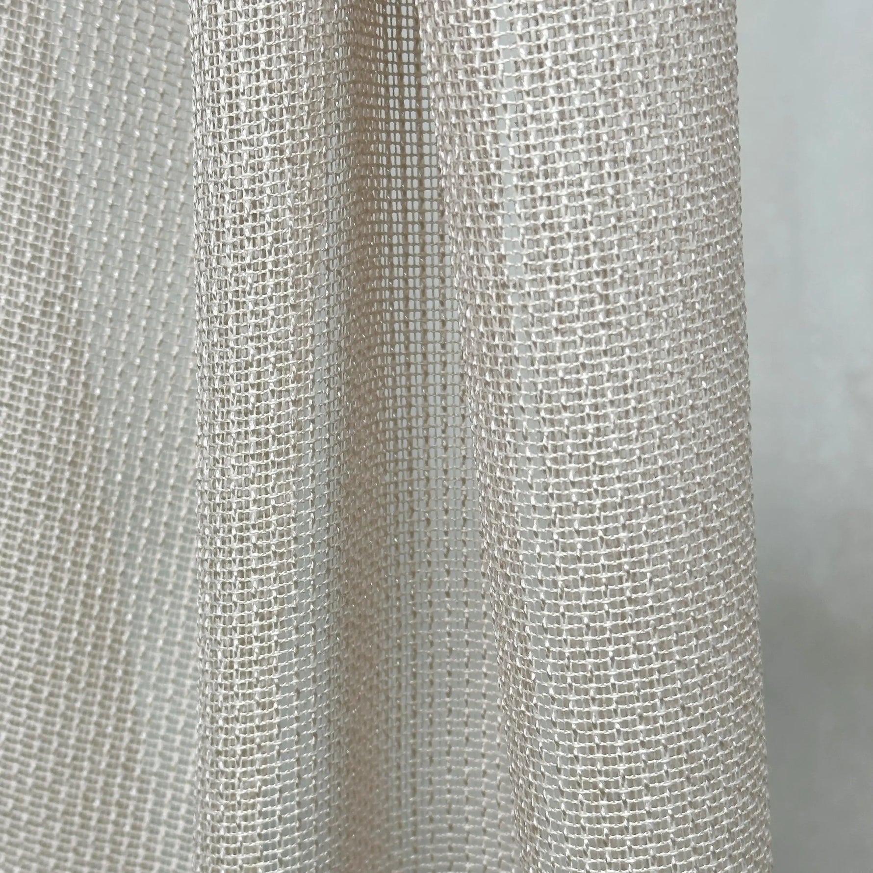 Close-up of textured beige curtains fabric with a subtle pattern