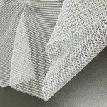 Close-up of a textured white tulle fabric on a dark surface