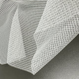 Close-up of a textured white tulle fabric on a dark surface
