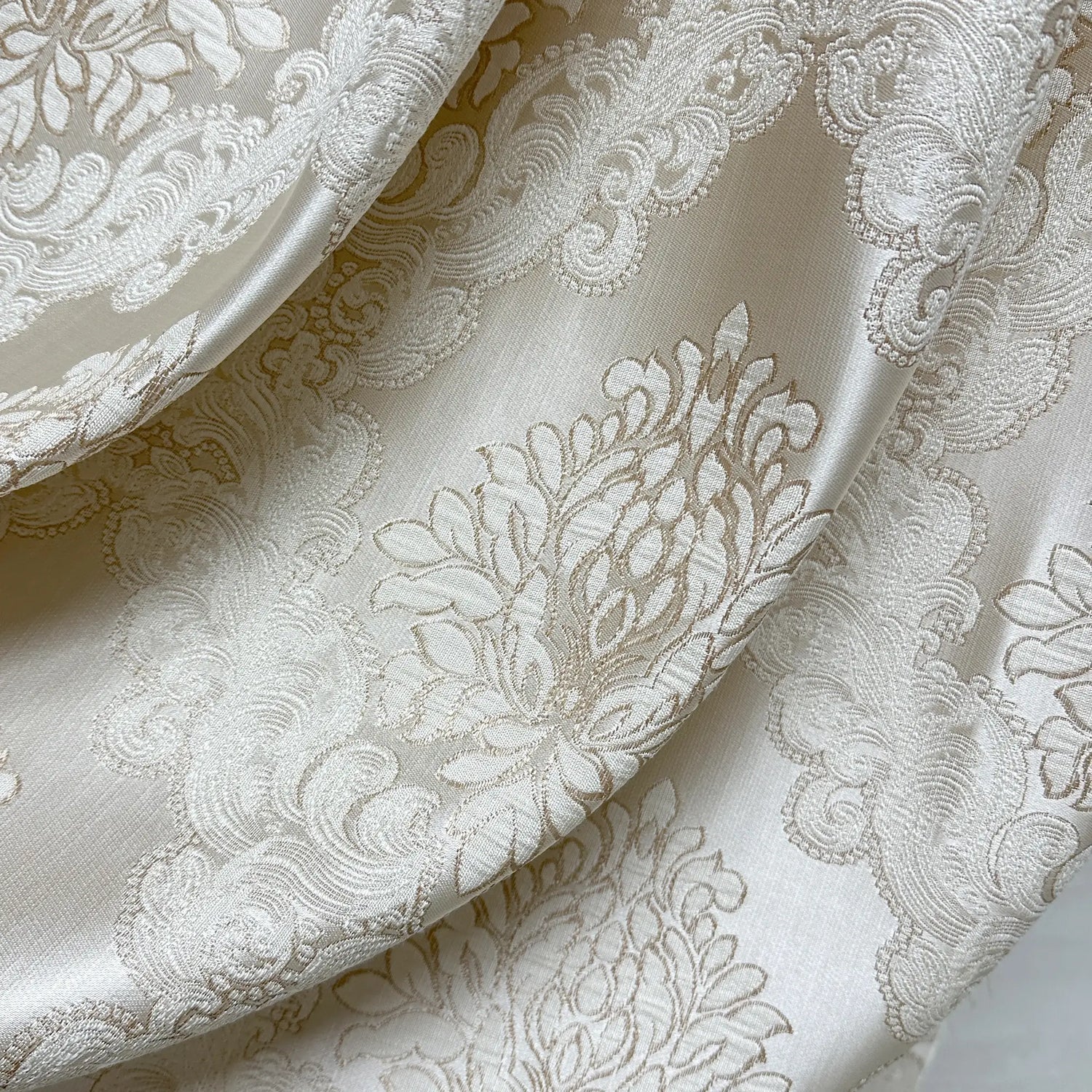 Close-up of decorative fabric with intricate patterns on a light background