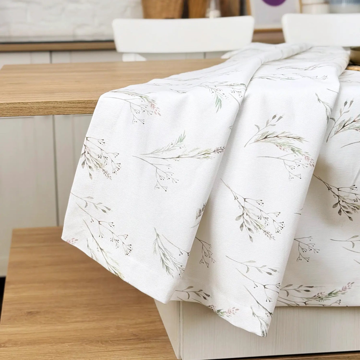 Floral-patterned tablecloth on a wooden table in a kitchen setting