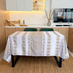 Dining table with a patterned tablecloth in a kitchen setting