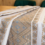 Patterned bedspread on a bed with a wooden headboard
