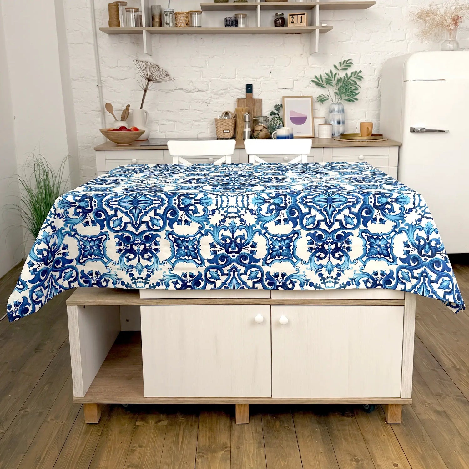 Blue and white patterned tablecloth on a wooden table in a kitchen setting.